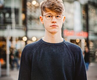 young man with downtown area in background can use his first credit card to make smart purchases SheeksFreaks Financial Skills for Young Adults