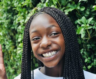 teenager with big smile shows peace sign outside on a sunny day SheeksFreaks Financial Skills for Young Adults